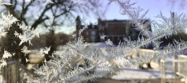 beautiful frost on the window with a view across campus of st. cecilia's
