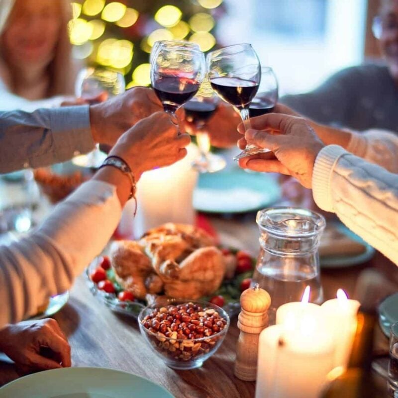 people around the table toasting at a holiday gathing