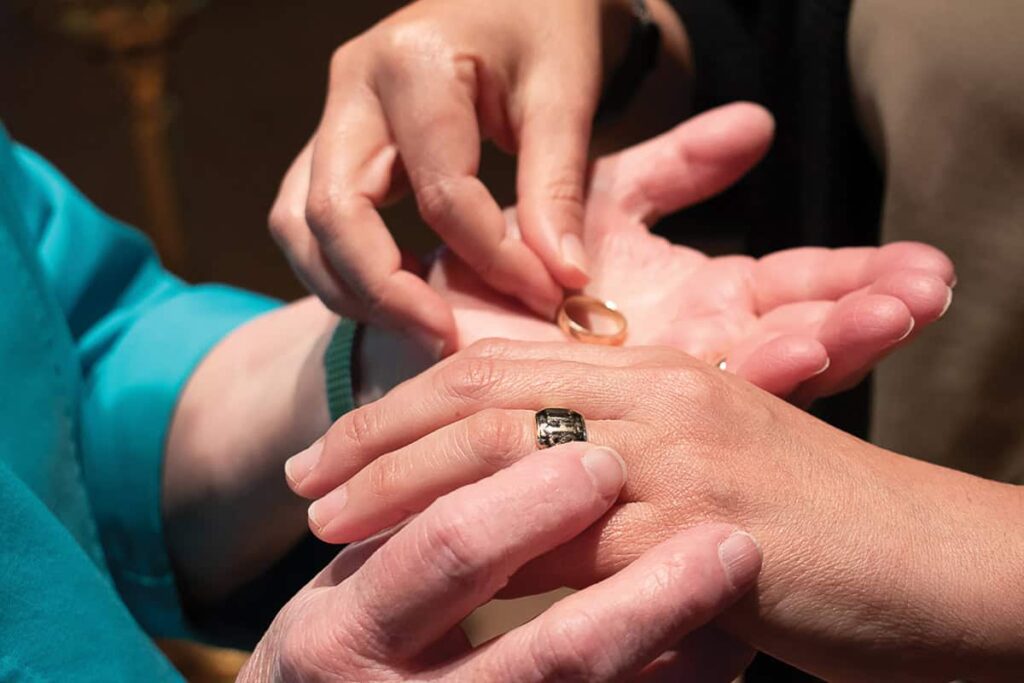Sister Helga removes the ring of her former community as the prioress, Mary Elizabeth Schweiger, places the ring worn by the sisters of Mount St. Scholastica on Sister Helga’s finger.