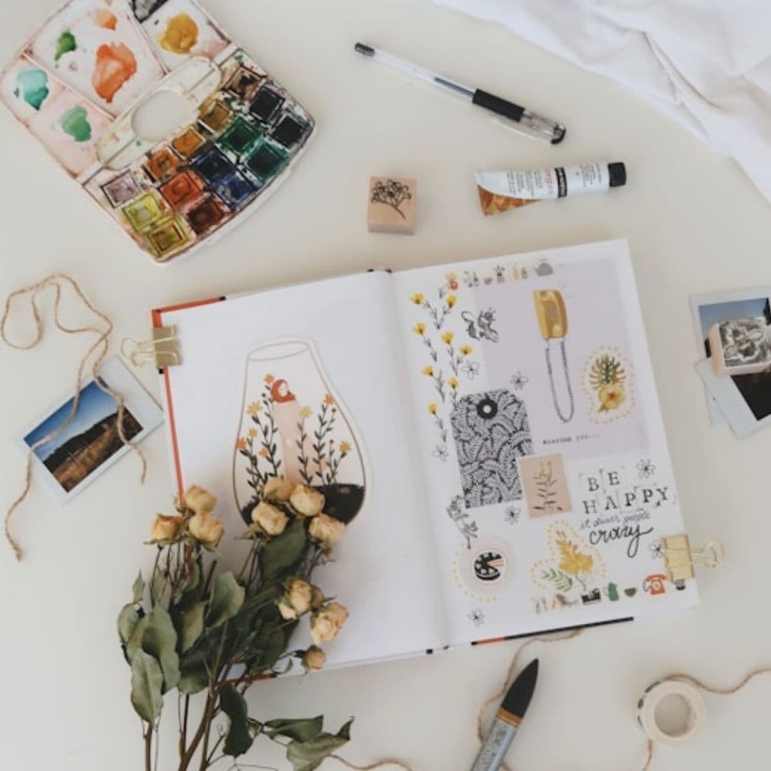art journal with art supplies on table