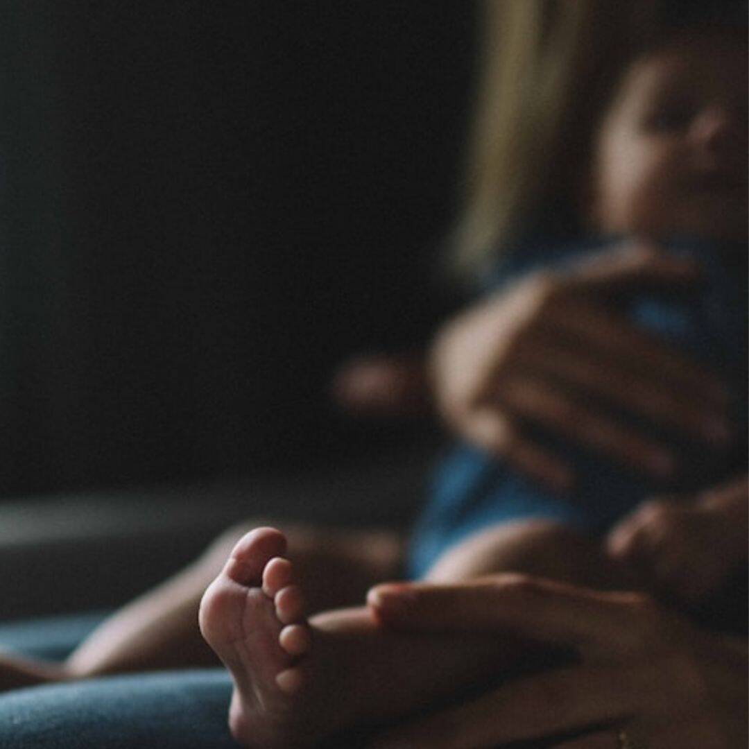 close up of child's feet while being held by its mother