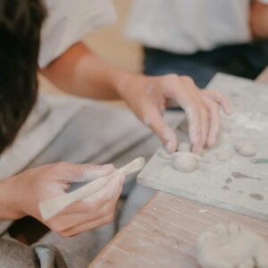 close-up of person's hands working on clay piece