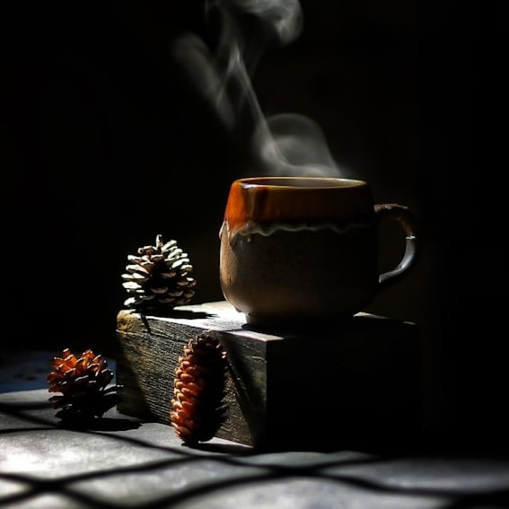 steaming coffee with pine cones around
