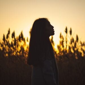 woman in the morning sun looking up to heaven