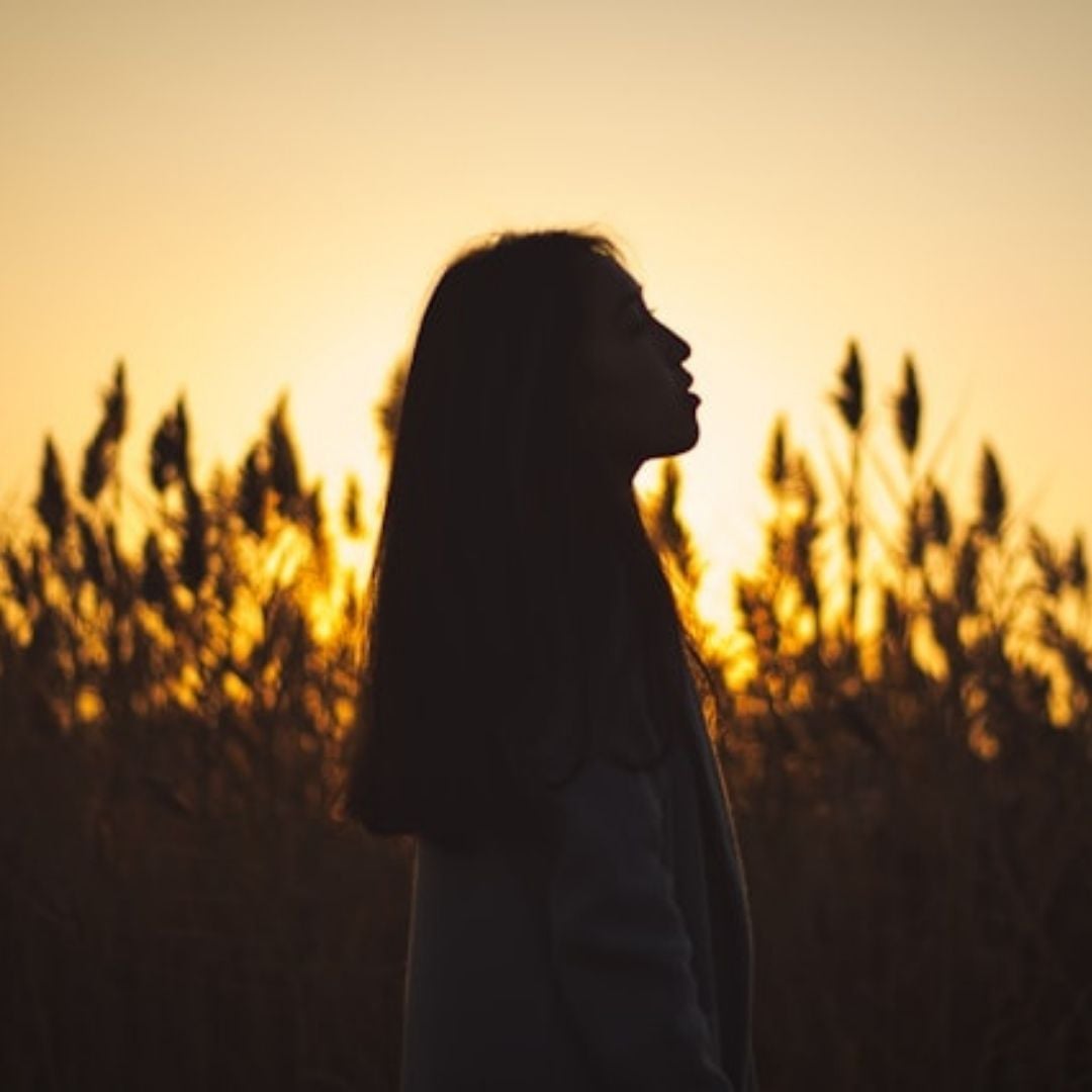 woman in the morning sun looking up to heaven